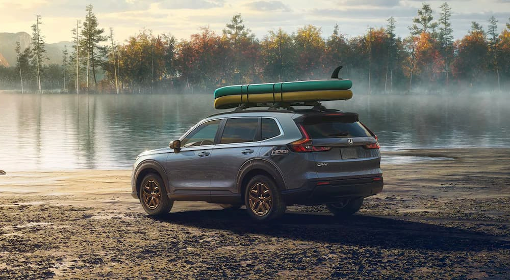 A silver 2025 Honda CR-V Hybrid EX HPD parked at a lake.