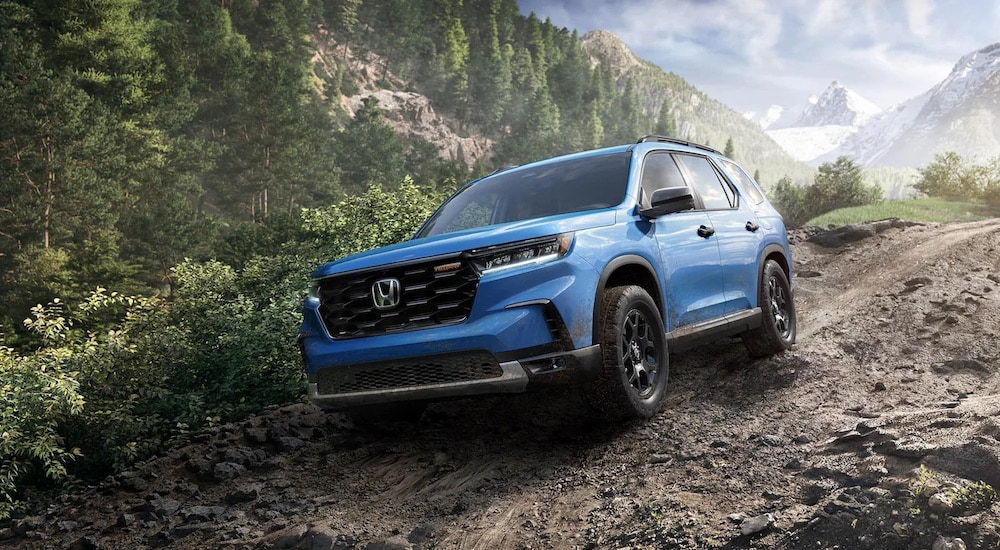 A blue 2025 Honda Pilot Trailsport is shown from the front at an angle.