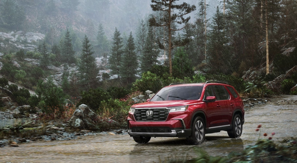Red 2025 Honda Pilot Elite for sale near Naperville parked off-road.