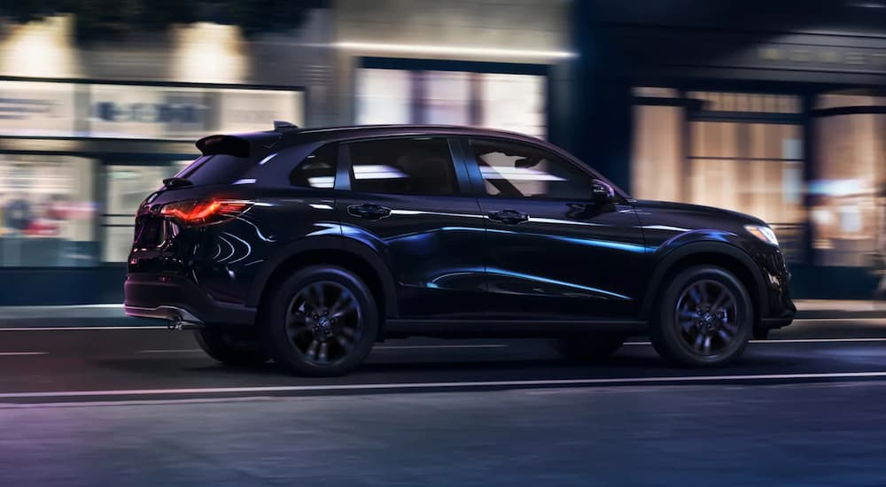A black 2026 Honda HR-V driving in a city at night