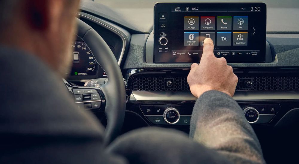 A man using the infotainment display in a 2025 Honda CR-V Hybrid for sale in Schaumburg