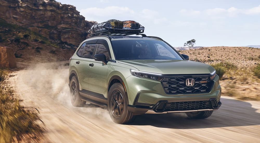 A green 2026 Honda CR-V TrailSport off-roading on a dirt trail