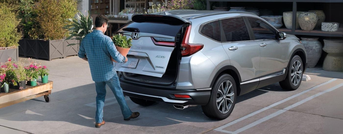 A person using the power rear liftgate on their silver 2021 Honda CR-V touring.