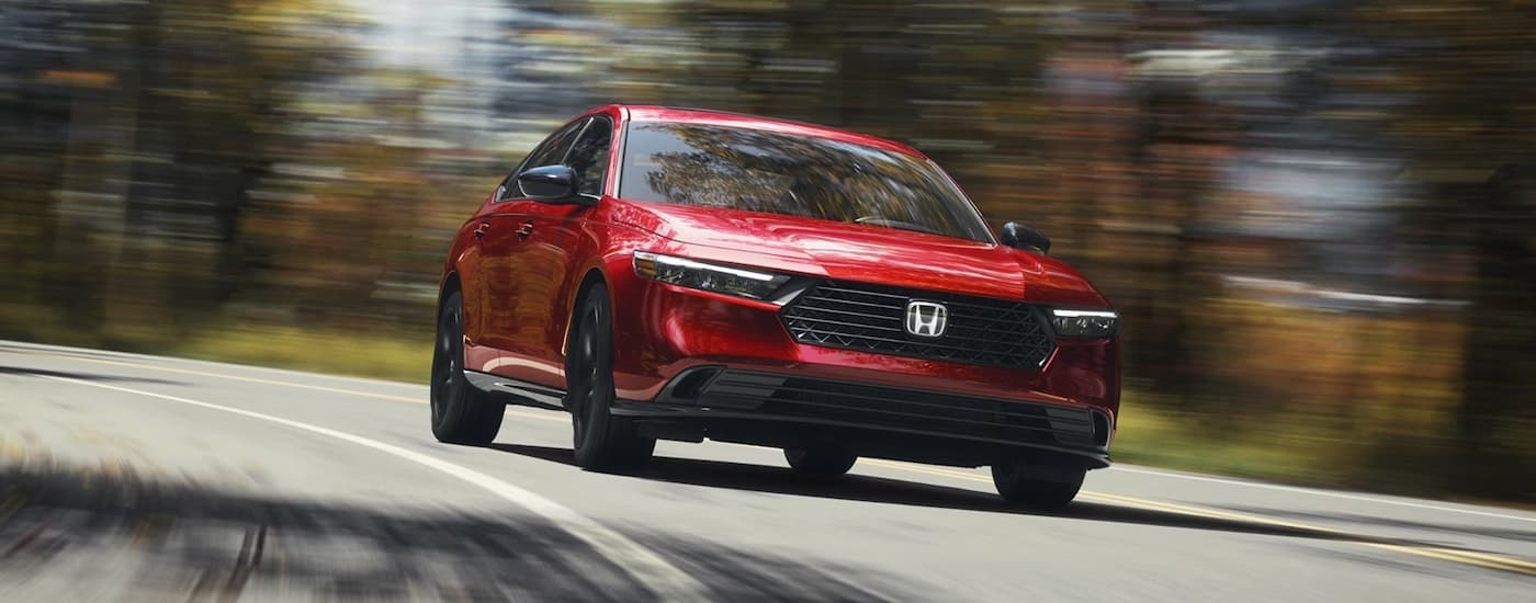 Red 2026 Honda Accord driving on a winding road