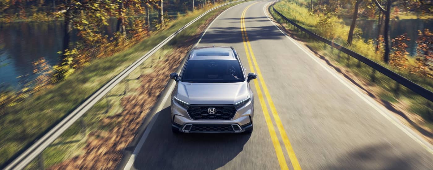 White 2026 Honda CR-V driving down an open road.