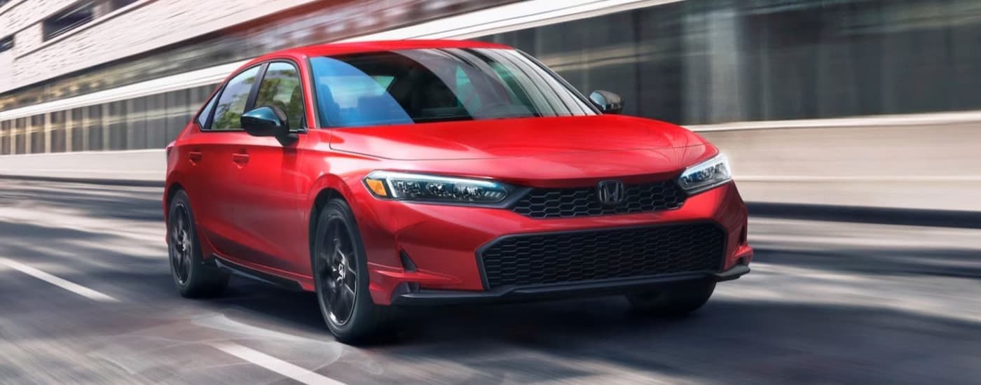 A red 2026 Honda Civic driving on a highway.