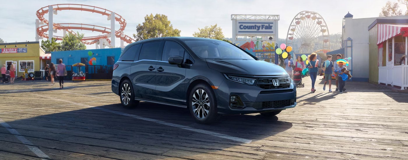 Right angled view of a black 2025 Honda Odyssey parked on a boardwalk.