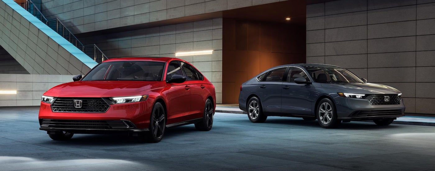A red 2024 Honda Accord Sport-L Hybrid and a grey 2024 Honda Accord LX parked next to each other.
