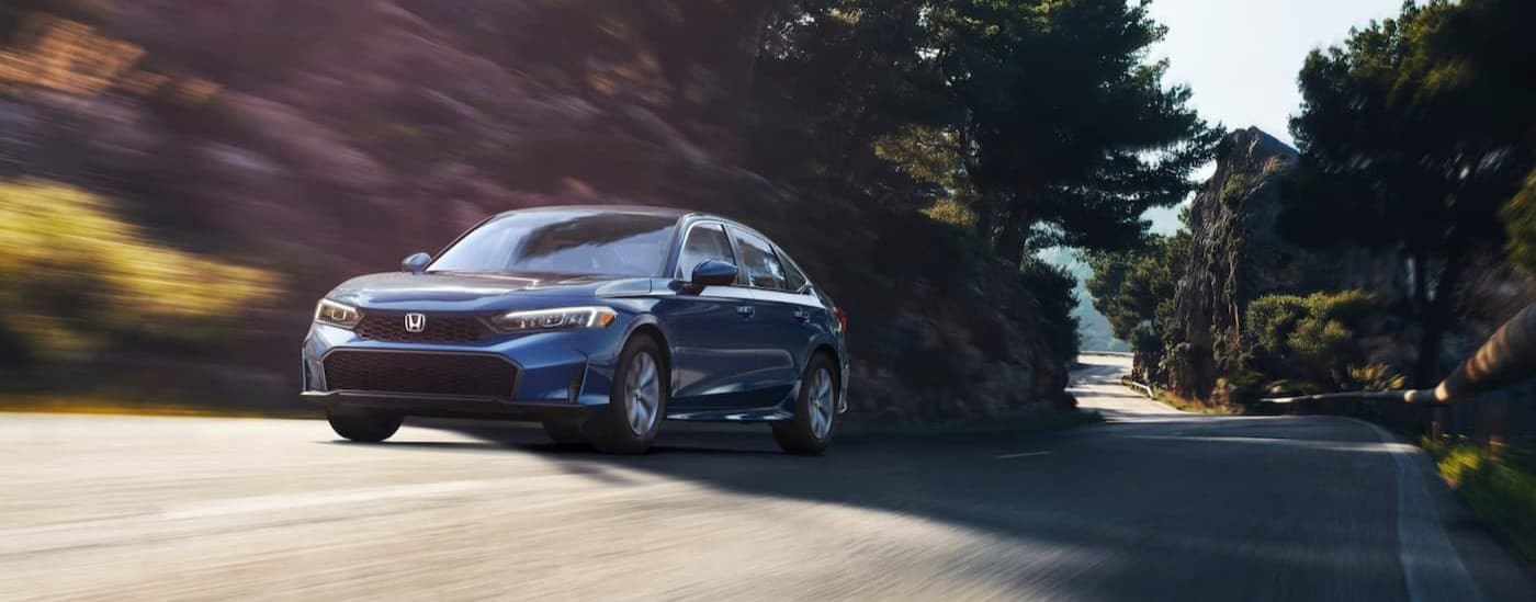 A blue 2025 Honda Civic drivinig to a Honda dealer near Wheaton.